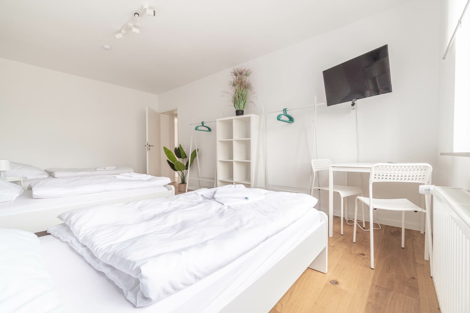 Schlafzimmer mit Arbeitsplatz und Fernseher in einer Wohnung von KAMA Rooms