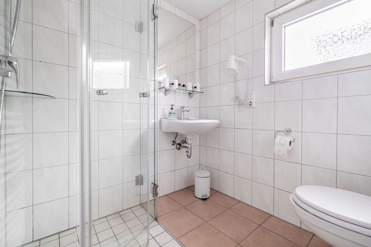 Badezimmer mit ebenerdiger Dusche und WC