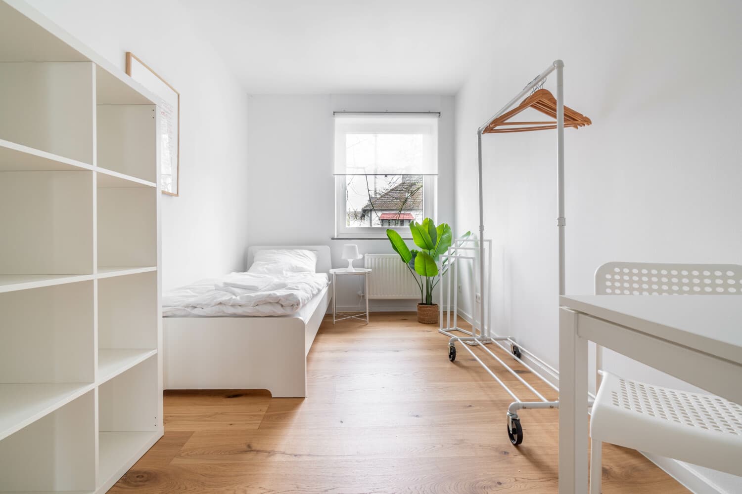 Schlafzimmer mit Einzelbett und Kleiderständer
