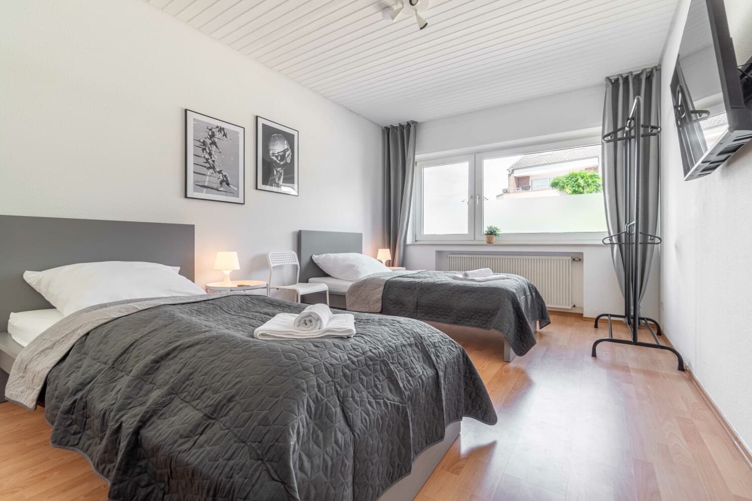 Schlafzimmer mit zwei Einzelbetten und grauen Tagesdecken