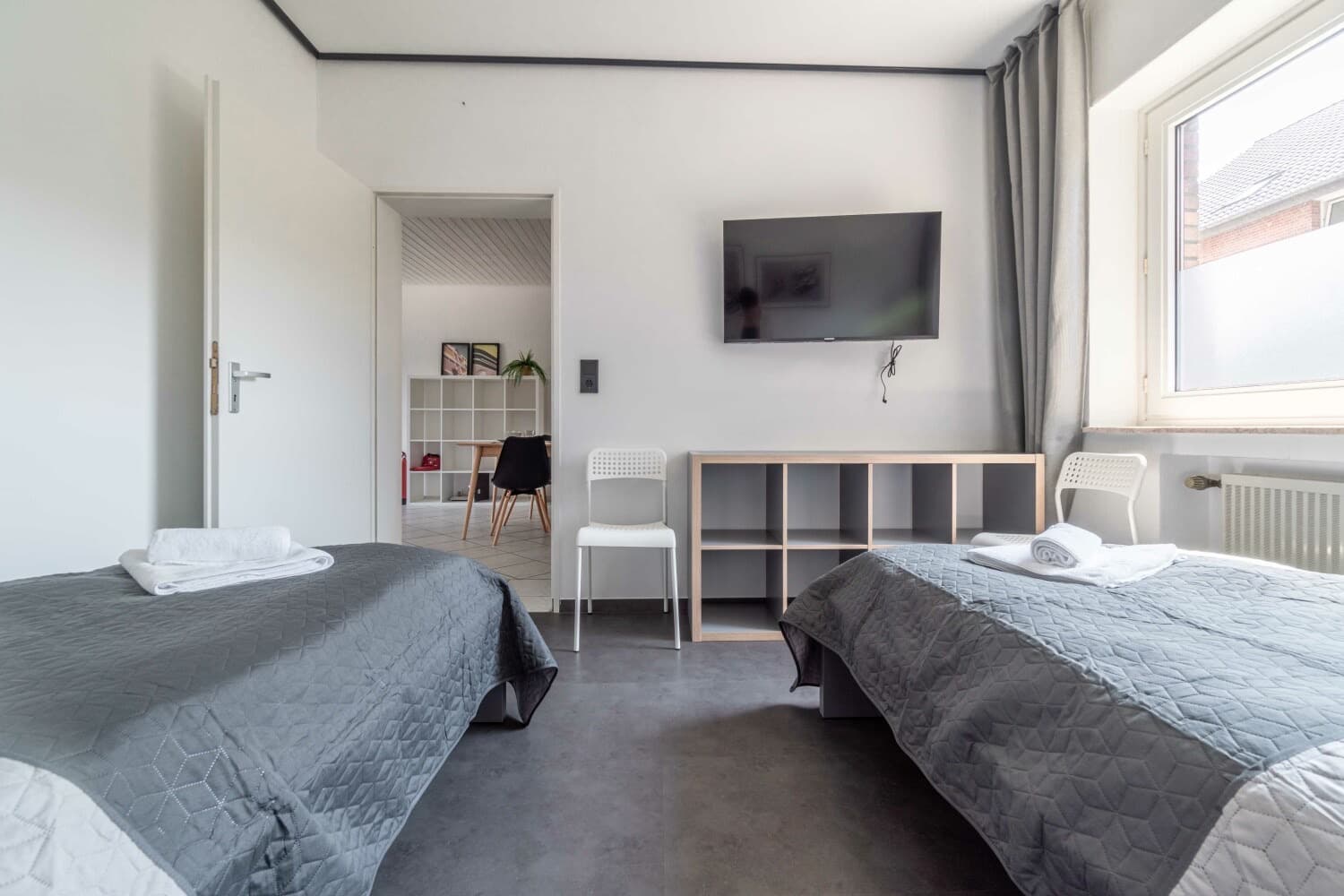 Schlafzimmer mit zwei Einzelbetten und Fernseher