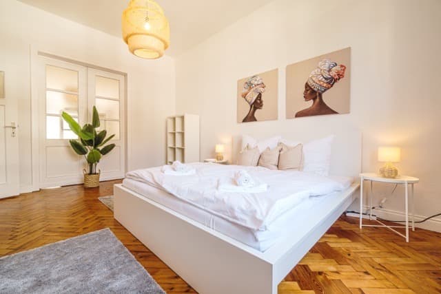 Schlafzimmer mit Doppelbett und Fischgrätparkett